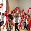 Dzieci tańczą z czerwonymi chustkami