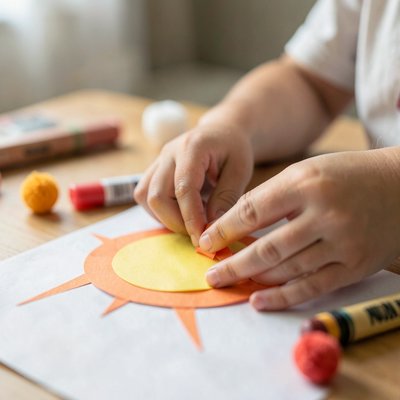 Zbliżenie rąk dziecka przyklejających promyk